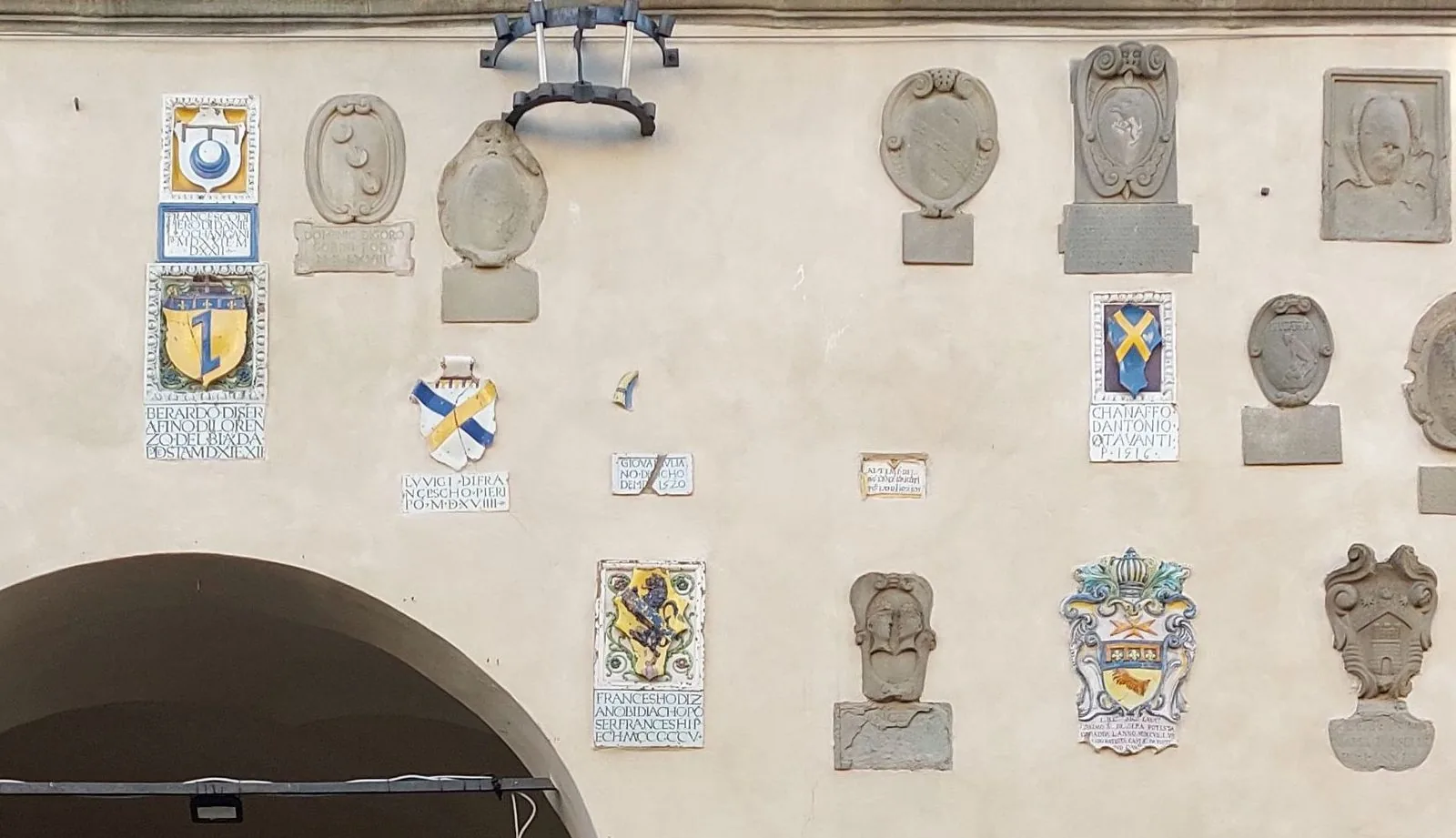 Facciata del Palazzo del Podestà di Radda in Chianti con stemmi in pietra e in terracotta invetriata colorata e l'arco del loggiato