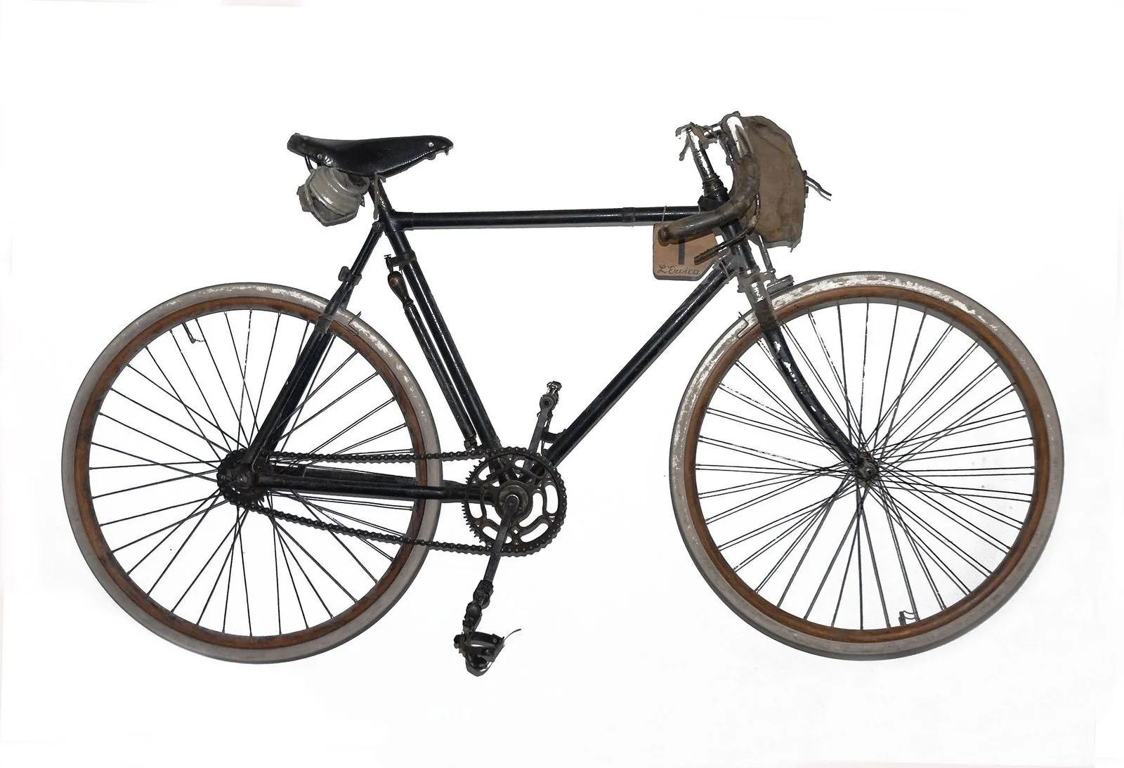 Bicicletta da corsa d'epoca con telaio nero, sella in cuoio, borraccia e borsello al manubrio, con la targa numero 1 de L'Eroica